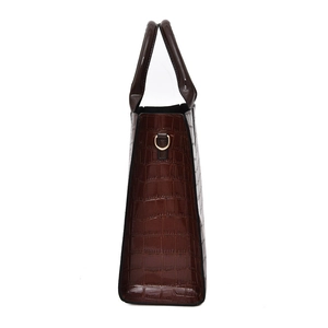 Brown crocodile embossed tote bag in side view featuring golden metal D-ring hardware