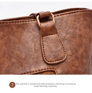Close-up of brown lychee leather handbag with reinforced stitching and gold D-ring