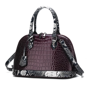 Deep burgundy crocodile-embossed handbag with snakeskin-patterned handles and shoulder strap