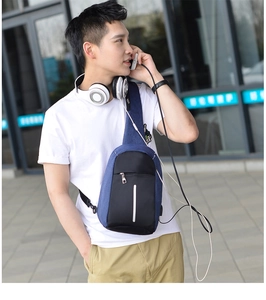 Détail du sac bandoulière avec port de charge USB et bande réfléchissante de sécurité