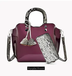 Detail of purple patent leather tote and snakeskin pattern wallet with metallic hardware