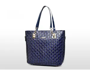 Detail of dark blue tote bag with 3D geometric diamond texture and gold chain handles