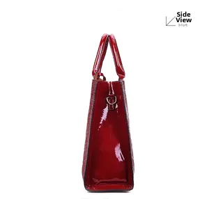 Side view of bright red patent leather handbag with glossy finish and metal D-ring hardware