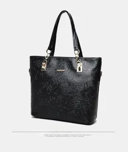 Detail view of the rose embossed texture and gold logo on black large capacity tote bag