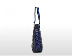 Side view of dark blue handbag featuring 3D geometric quilted texture and metallic D-rings