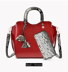 Front view of red patent leather tote bag set with black and white snake print accents