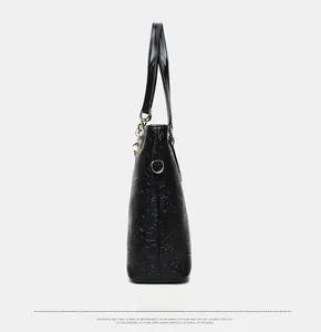 Side view of black tote bag featuring detailed floral camellia embossed faux leather