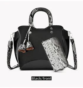 Front view of black patent leather handbag with snakeskin handle and matching long wallet