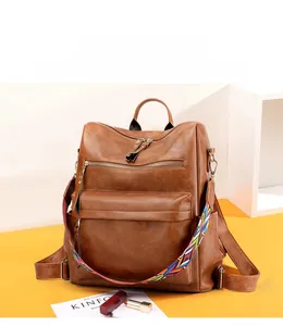 Dettaglio dello zaino vintage marrone con trama in pelle e tracolla intrecciata colorata