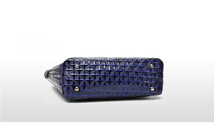 Detail view of navy blue handbag bottom with star embossing and four gold protective feet