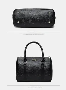 Detail of embossed rose pattern on black Boston bag with gold logo and protective studs