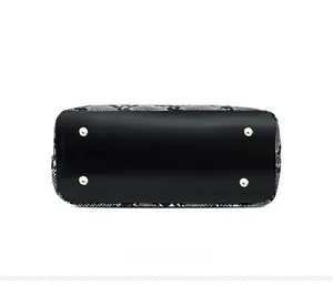 Bottom view of handbag with snakeskin pattern and four golden protective metal feet