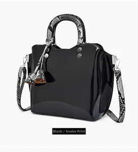 Detail view of black patent leather handbag with stylish black and white snake print handles