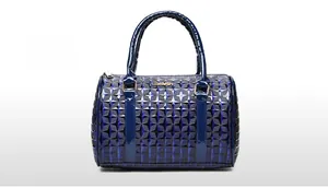 Close-up of blue patent leather handbag with embossed star pattern and metal logo detail