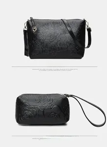 Detail of black rose embossed leather handbag and wristlet set with adjustable strap