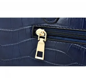 Close-up of crocodile embossed dark blue leather with premium gold metal zipper detail