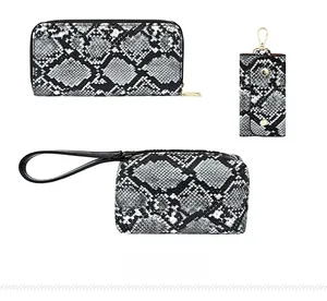 Detail view of python print wallet and matching accessories with gold-tone hardware