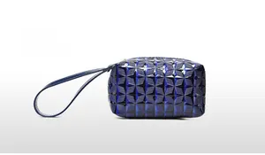 Close-up of deep blue glossy clutch bag with 3D geometric quilted pattern and wristlet strap