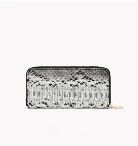 Detail of snake pattern clutch bag with textured faux leather and gold metal zipper