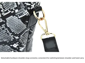 Close-up of detachable gold metal hardware buckle on snakeskin pattern handbag