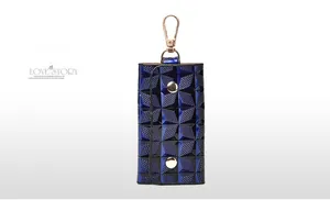 Detail of navy geometric quilted key pouch with gold metal hook and snap buttons