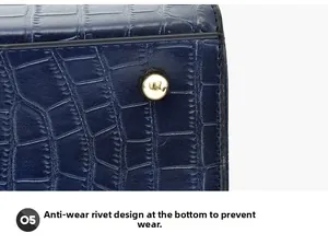 Close-up of golden protective studs on the base of a blue crocodile embossed handbag