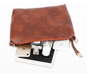 Detail van vintage bruine envelop-clutch met ruimte voor tablet en accessoires