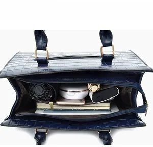 Detail showing the spacious dark blue crocodile embossed interior with functional pockets