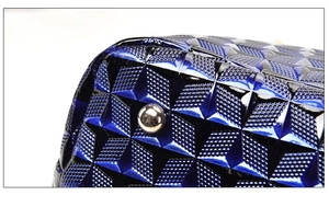 Detail of navy blue textured handbag base with silver protective metal feet studs