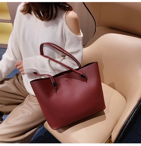 Detail of dark red matte leather tote bag with Forever Young print on shoulder strap