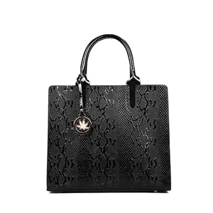 Glossy black snakeskin embossed Kelly handbag with gold maple leaf charm and handle