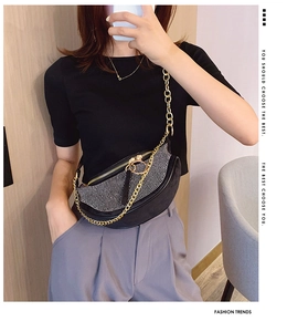 Chic rhinestone crescent bag with gold chain strap shown on model in stylish setting