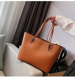 Brown faux leather tote bag detail with Forever Young logo and long shoulder straps