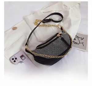 Macro shot showing sparkling silver rhinestones on a black suede crescent crossbody bag