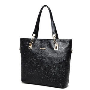 Black tote bag with rose embossing, golden hardware, and dual handles, 45-degree view