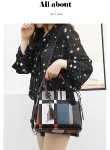 Detail of color-block tote bag with leather handles and cat-shaped metal charm