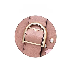 Detail of pink pebbled leather handbag with polished gold semi-circle metal clasp