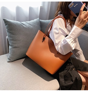 Detail of a large brown leather tote bag with Forever Young text in a casual home setting