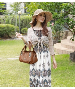 Detailed view of a brown pebbled leather tote bag with stylish metallic handle accents
