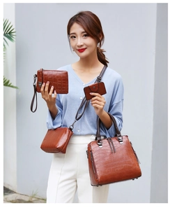 Détail d'un ensemble de quatre sacs à main marron texture crocodile avec sac cabas