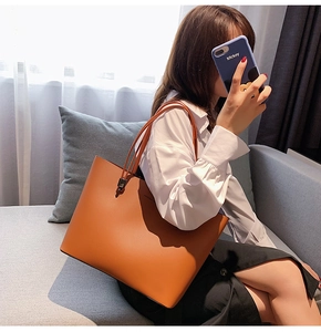 Detail of a brown orange tote bag with thin shoulder straps and Forever Young text