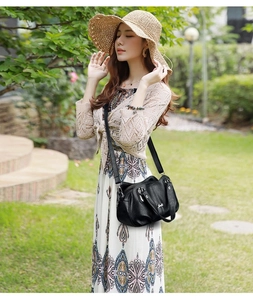Close-up of black PU shoulder bag with decorative stitching and functional zipper pocket