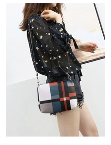 Detail of color-block crossbody bag featuring geometric patchwork and slim brown strap
