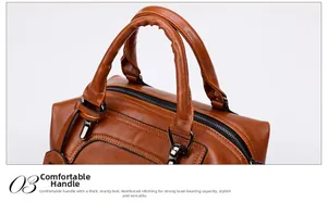 Macro detail of thick handle, metal buckle, and stitching on brown faux leather bag