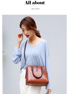Sac à main marron motif crocodile porté par un mannequin sur un fond gris minimaliste