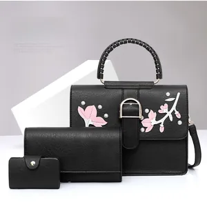 Detailed set of black PU leather handbags featuring floral embroidery and pearl accents