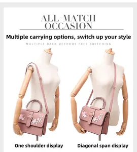 Pink crossbody bag with floral embroidery and pearls shown on a dress mannequin