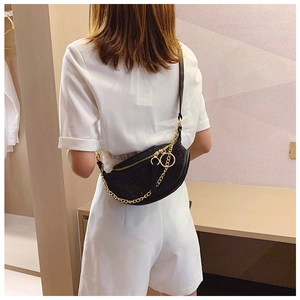 Detailed back view of a crescent rhinestone chest bag with gold chain and black strap