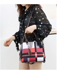 Detailed side view of women's checkered tote bag with tassel and shoulder strap