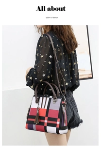 Detailed view of color-block tote bag with tassel charm and adjustable shoulder strap
